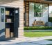 Smart outdoor locker system in a modern backyard with open compartments, digital touchscreen, and security camera, illustrating secure and weatherproof package storage.