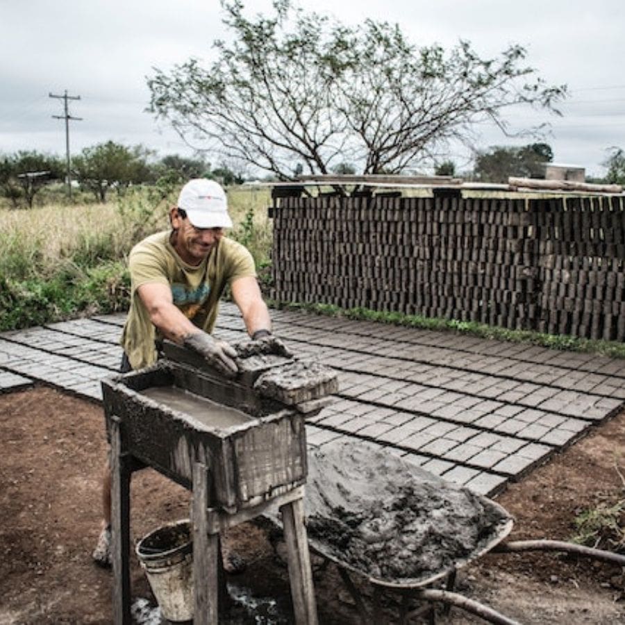 man laying a concrete brick shed foundation