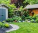 An eco-friendly backyard with native plants, rain barrels, drought-tolerant landscaping, and a well-organized shed. The yard is vibrant, teeming with birds and butterflies, representing sustainable and harmonious living with nature.