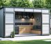 Modern outdoor 7x7 storage shed with fold-down serving counter, integrated bench seating, and decorative wall panels, set in a beautifully landscaped backyard.