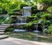 Serene backyard showcasing a multi-tiered water fountain and lush vegetation, exemplifying soundscaping techniques for creating a peaceful outdoor environment.