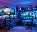 Interior of a transformed storage shed turned into a high-tech gaming paradise, showcasing multiple monitors, gaming chairs, and colorful RGB ambient lighting.