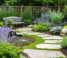 A tranquil backyard garden featuring winding pathways lined with lavender, rosemary, and various textured plants. A small water feature adds a soothing element, while strategically placed benches offer a space to relax and enjoy the sensory experience.