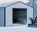 A shed with modern ice and snow management features such as snow barriers, heat cables, and a snowblower, surrounded by a snowy landscape.