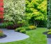 A garden depicted in different seasons, featuring colorful spring blooms, lush summer greenery, autumn leaves, and winter evergreens, alongside elements like garden sheds and mulch, illustrating continuous plant care.