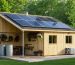 An eco-friendly shed with solar panels, large windows for natural light, and a rainwater collection system, symbolizing sustainable and energy-efficient design in a lush green setting.