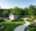 Aerial view of a one-acre property with expertly integrated garden shed, featuring flowing pathways, diverse plantings, and outdoor focal points such as pergolas and a water feature, illustrating a cohesive landscape design.