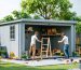 A creative depiction of a modular shed system being assembled like Lego blocks in a garden setting, showcasing panels, connectors, and frames being put together.