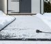 "A portable snow melting mat in use, effectively clearing snow and ice from a pathway leading to a shed, demonstrating safe and convenient winter maintenance."