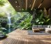 A beautifully designed outdoor workspace featuring a wooden deck, ergonomic seating, and a variety of plants and water features, illustrating the concept of biophilic design and natural productivity enhancement.