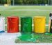 A collection of exterior paint cans including oil-based, acrylic latex, and epoxy options, suitable for shed maintenance and field marking. Brushes and a wooden shed are visible in the background, emphasizing durability and weather resistance for outdoor projects.