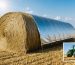 A UV-treated silage tarp covering a haystack under a clear sky, with a comparison of an old weathered tarp, demonstrating enhanced protection and longevity in an agricultural setting.