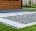 Illustration of a Tuff shed foundation using eco-friendly materials, including recycled concrete and permeable pavers, with sustainable landscaping surrounding the site.