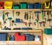 "Interior of a tool shed with tools on a pegboard and storage bins on shelves, designed for efficient organization."