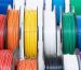 "Close-up of 3D printer filament spools in ASA, PETG, and UV-resistant PLA, photographed on a white background."