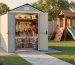 Compact 5x5 backyard shed on a gravel foundation near a playset, door open showing wall-mounted hooks, overhead shelves, and clear plastic bins of toys; short paver path, green lawn and fence softly blurred in warm golden-hour light.