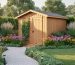 Wooden garden shed framed by tall grasses and evergreen shrubs at the corners, coneflowers and daylilies along the sides, low groundcovers, a gravel path lined with solar lights, and a small vine-covered trellis, photographed at golden hour with lawn and mature trees in the background.