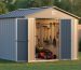 10x8 vinyl-coated steel storage shed with a sloped roof in a neat backyard, doors slightly open to show organized garden tools and a push mower, lit by golden-hour sunlight with a softly blurred lawn and fence behind.