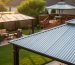 Eye-level photo of a backyard with three gazebos showing roofing materials—galvanized steel roof in sharp focus foreground, translucent polycarbonate midground, and powder-coated aluminum roof on a deck in the background at golden hour.
