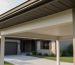 Close-up of an attached carport’s roof overhang where the eaves are enclosed at the point it meets the house wall for fire protection.