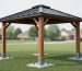 Backyard gazebo with a metal roof anchored to concrete footings, suggesting a permanent structure classification.