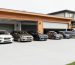 Wide view of a modern residential garage with multiple parked cars and tall garage doors, suggesting an eight-car layout and planning considerations.