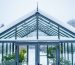 Backyard greenhouse frame and roof covered with heavy wet snow, emphasizing structural support in winter conditions.