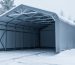 Heavy duty portable garage with a reinforced arched metal frame covered with fresh snow in an outdoor winter setting.