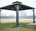 Metal gazebo in a backyard with anchoring hardware at the base and canopy fabric removed and prepared for winter wind and storms.